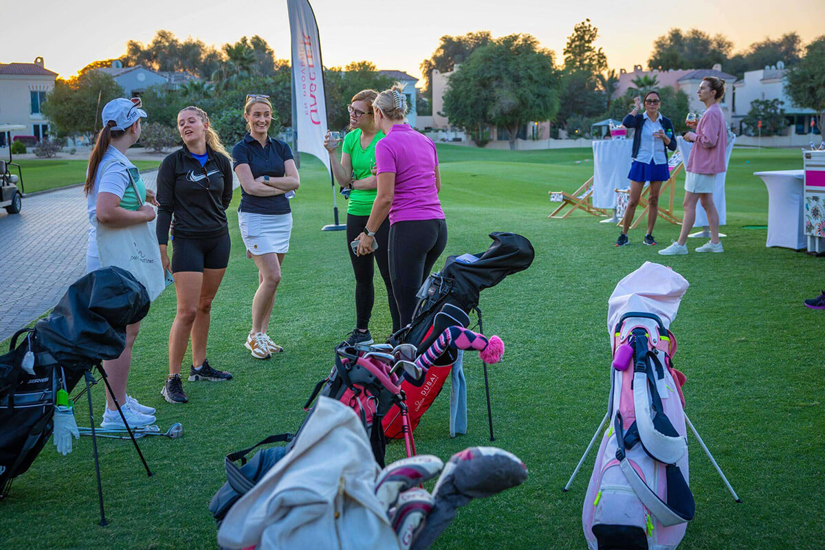 A smiling woman golfer celebrating on the course